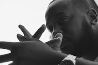 a black and white photo of a man holding his hand up
